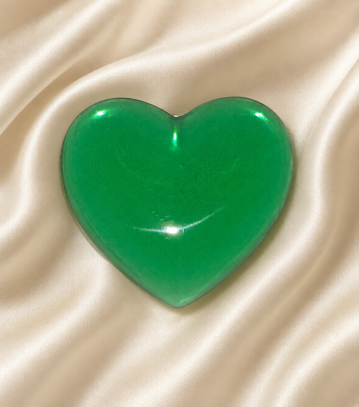 Generated image: Green heart on satin fabric.png