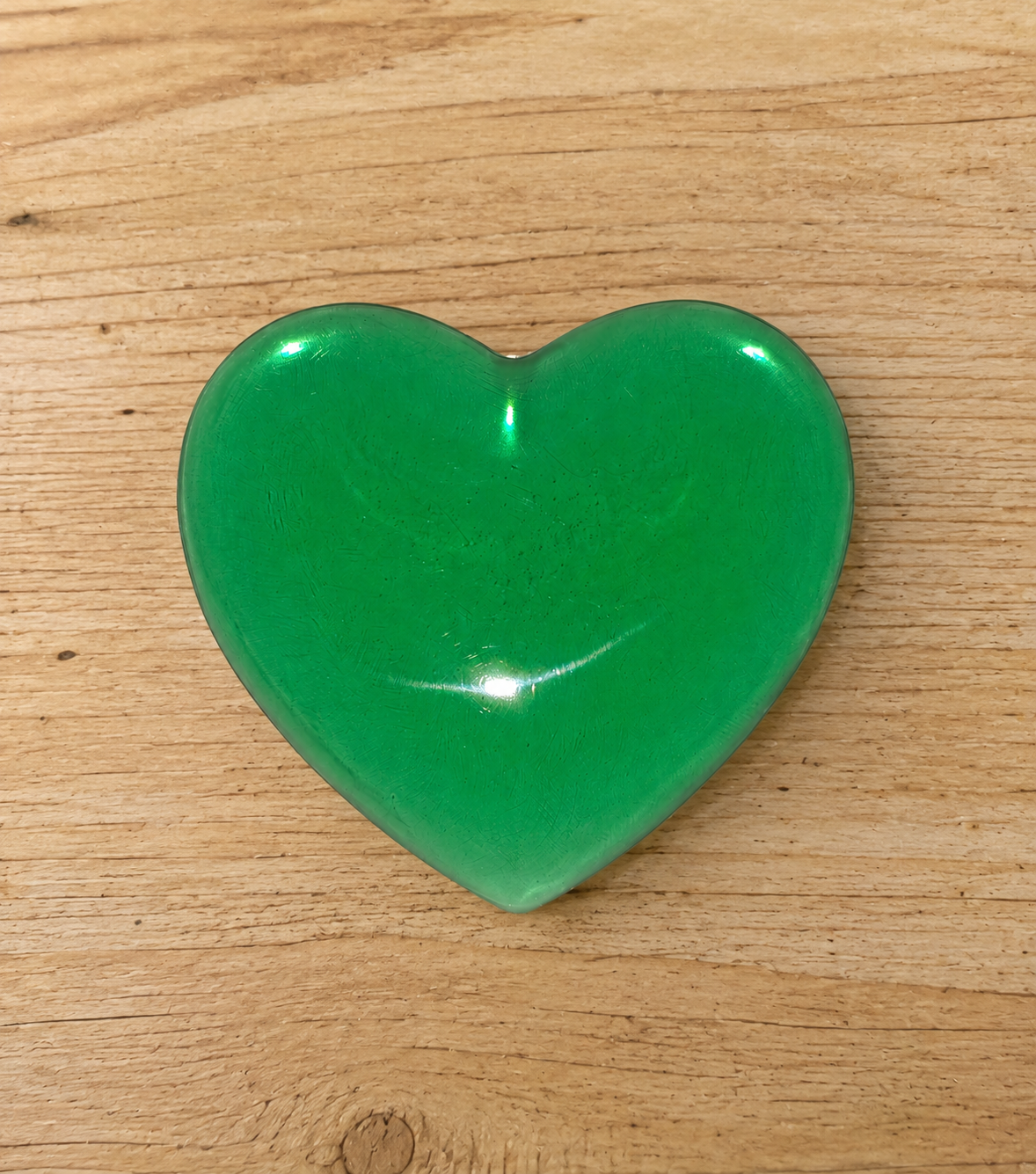 Generated image: Green heart on wooden surface.png