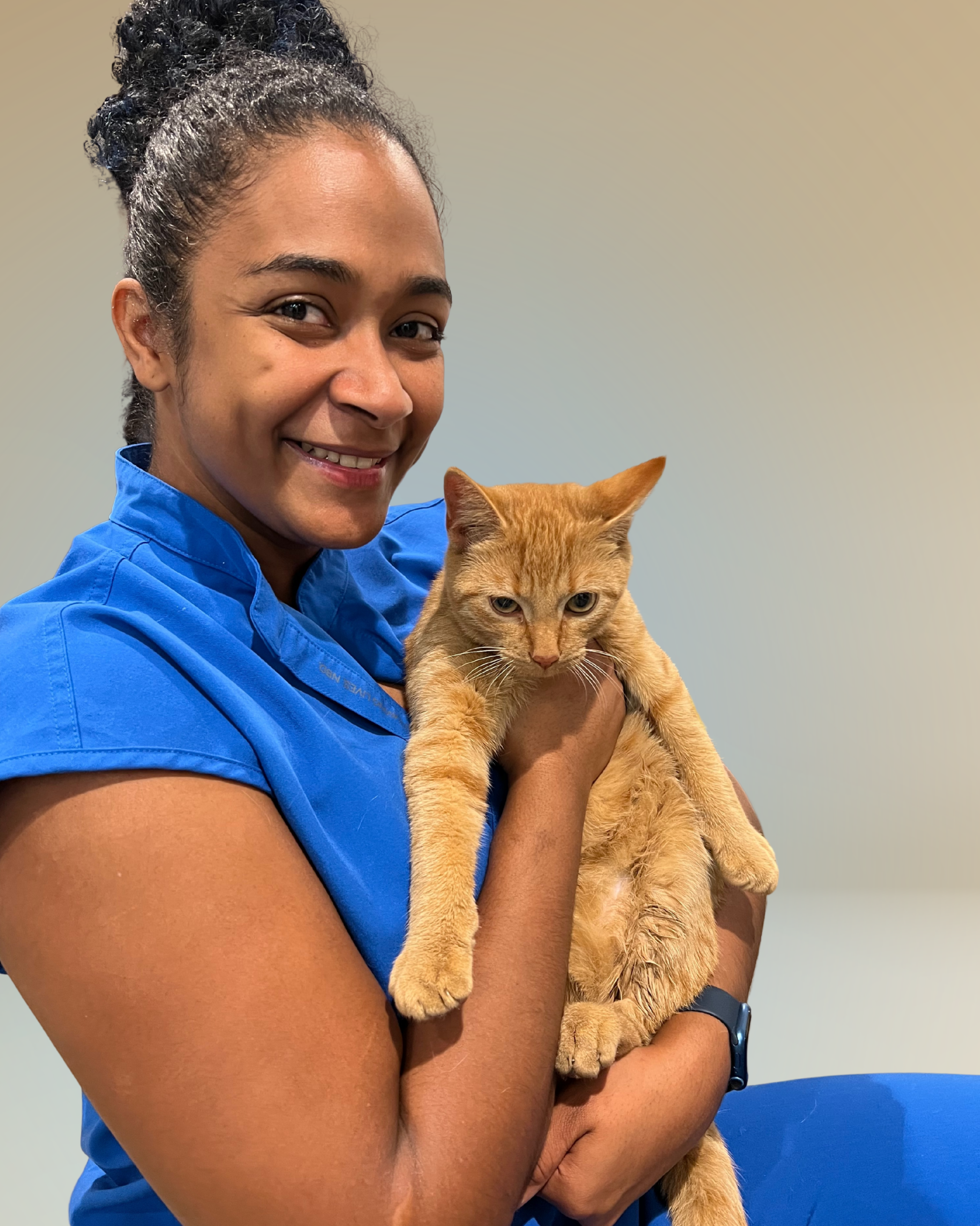 Dr Marcano in scrubs holding an orange cat