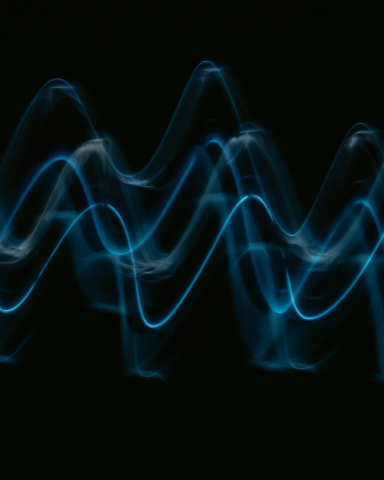 Blue wave light streaks against a black background.