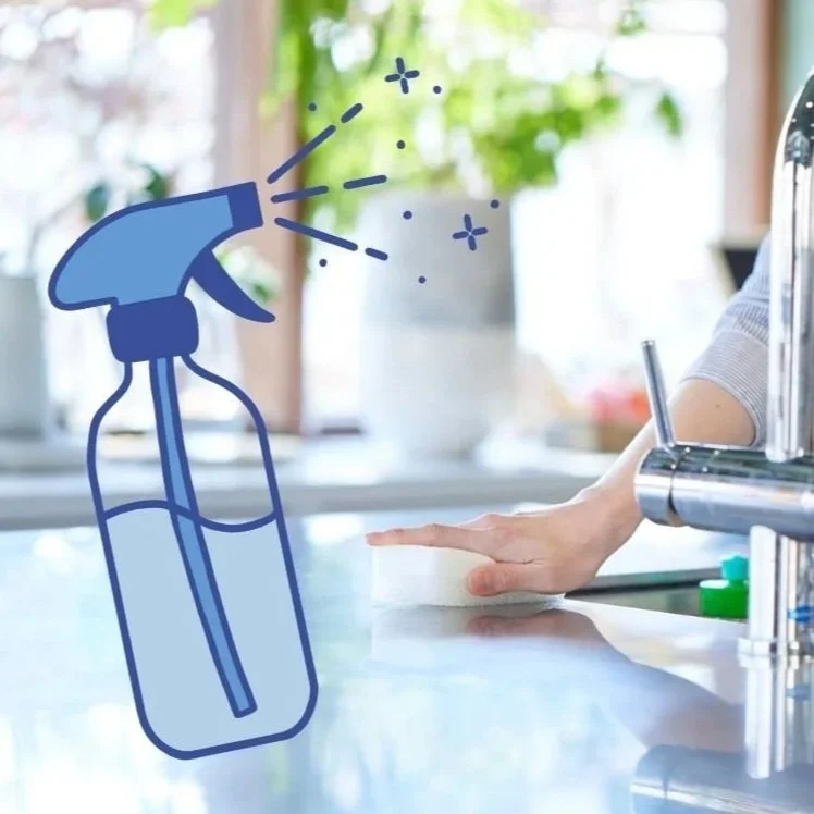 Illustration of a blue spray bottle with spray coming out, overlaid on a photo of a person disinfecting a kitchen countertop.