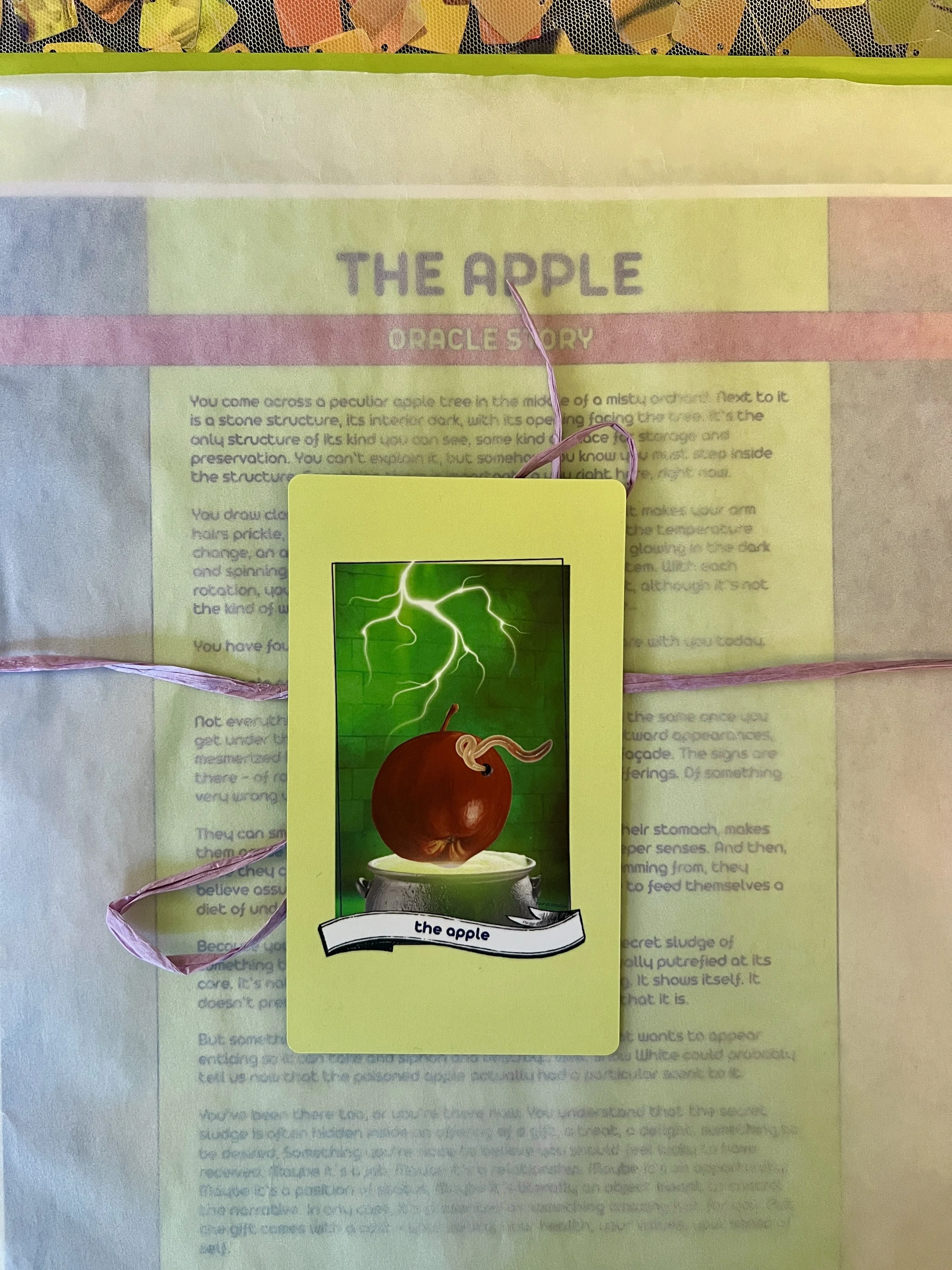 The Apple individual printed card and story sheet from Found Oracles shown bundled up with the card on top.