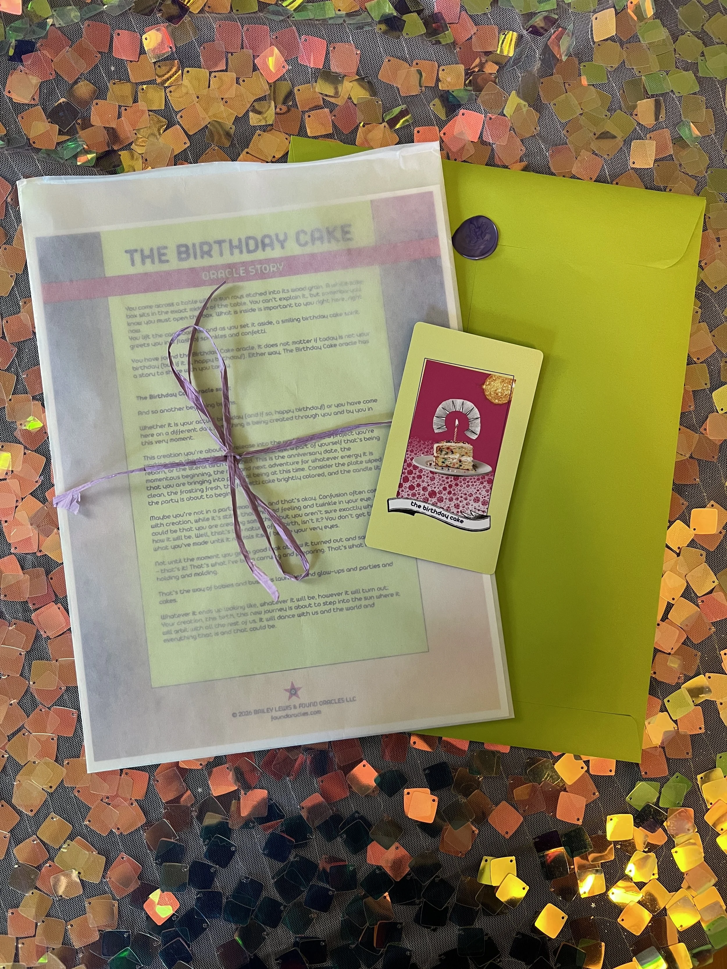 Flat lay shot of The Birthday Cake printed story card and story sheet from Found Oracles with purple wax sealed green envelope behind.