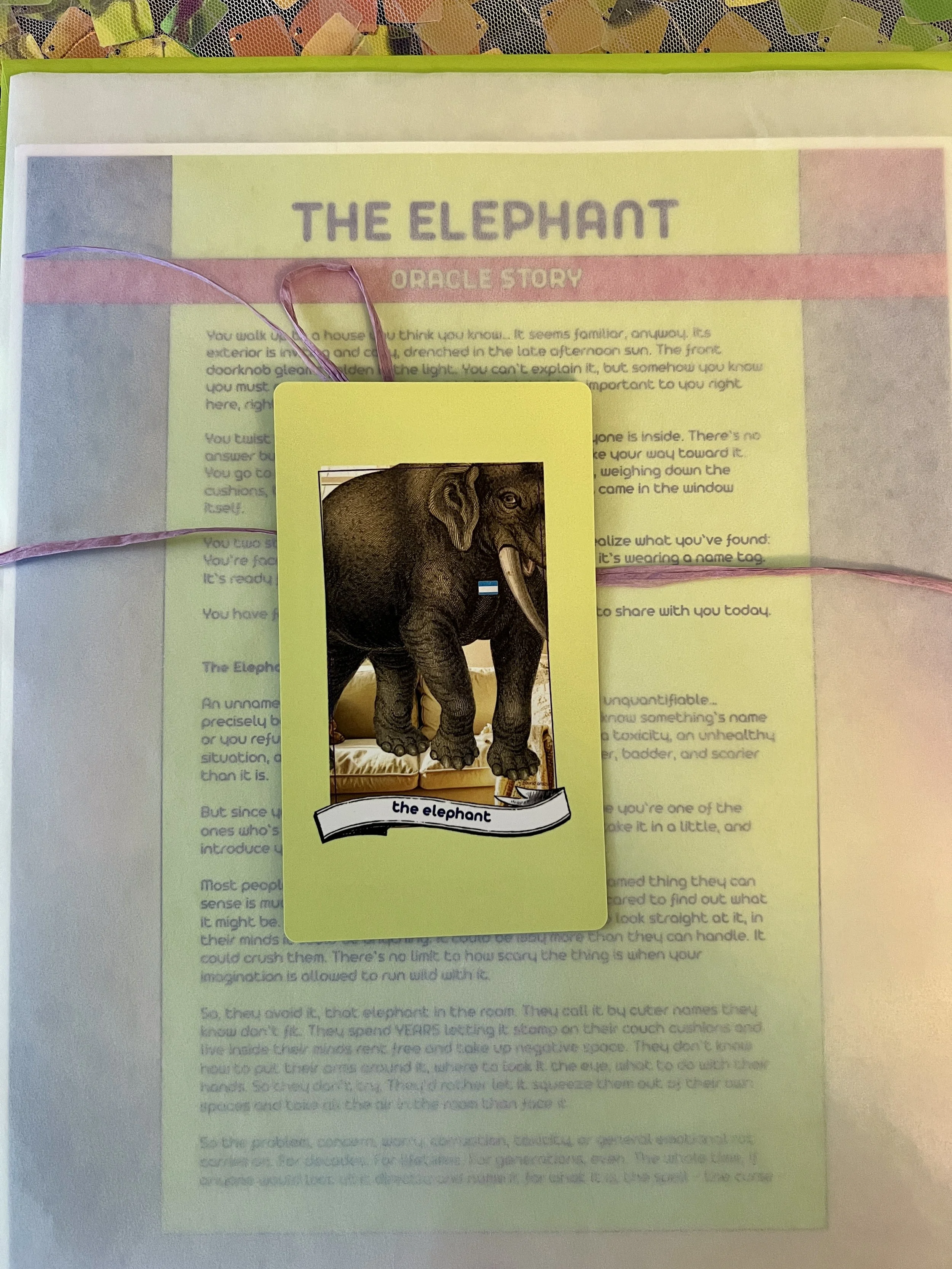 The Elephant individual printed card and story sheet from Found Oracles shown bundled up with the card on top.