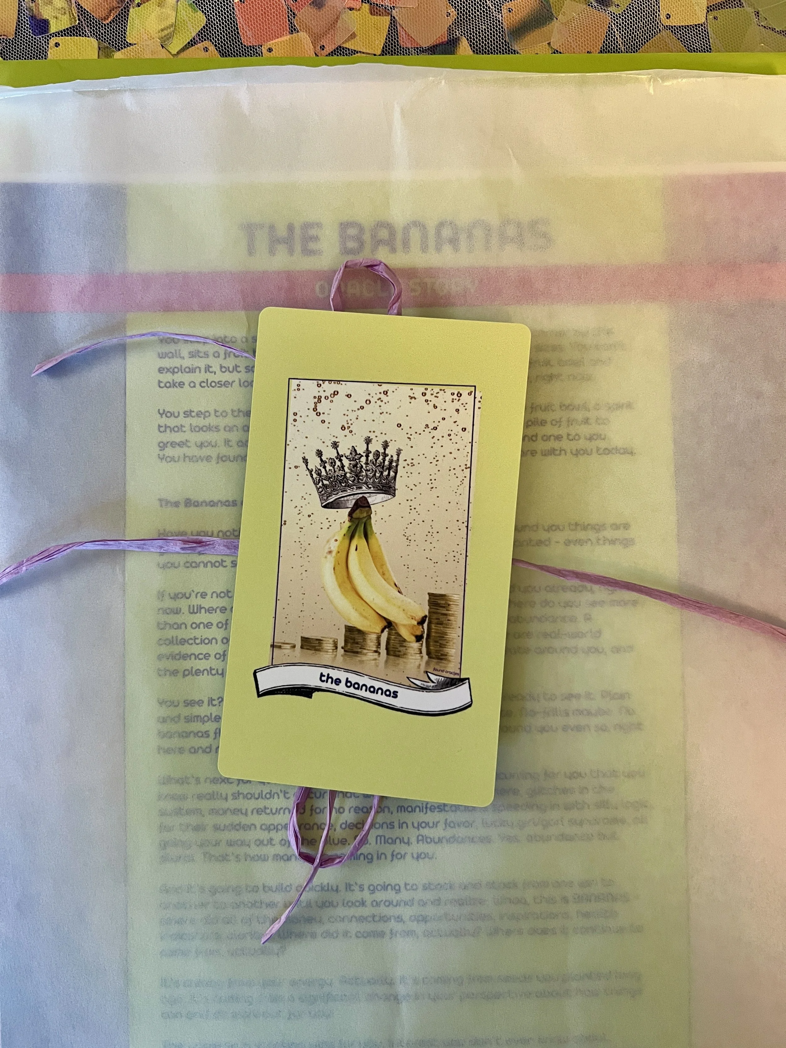 The Bananas individual printed card and story sheet from Found Oracles shown bundled up with the card on top.