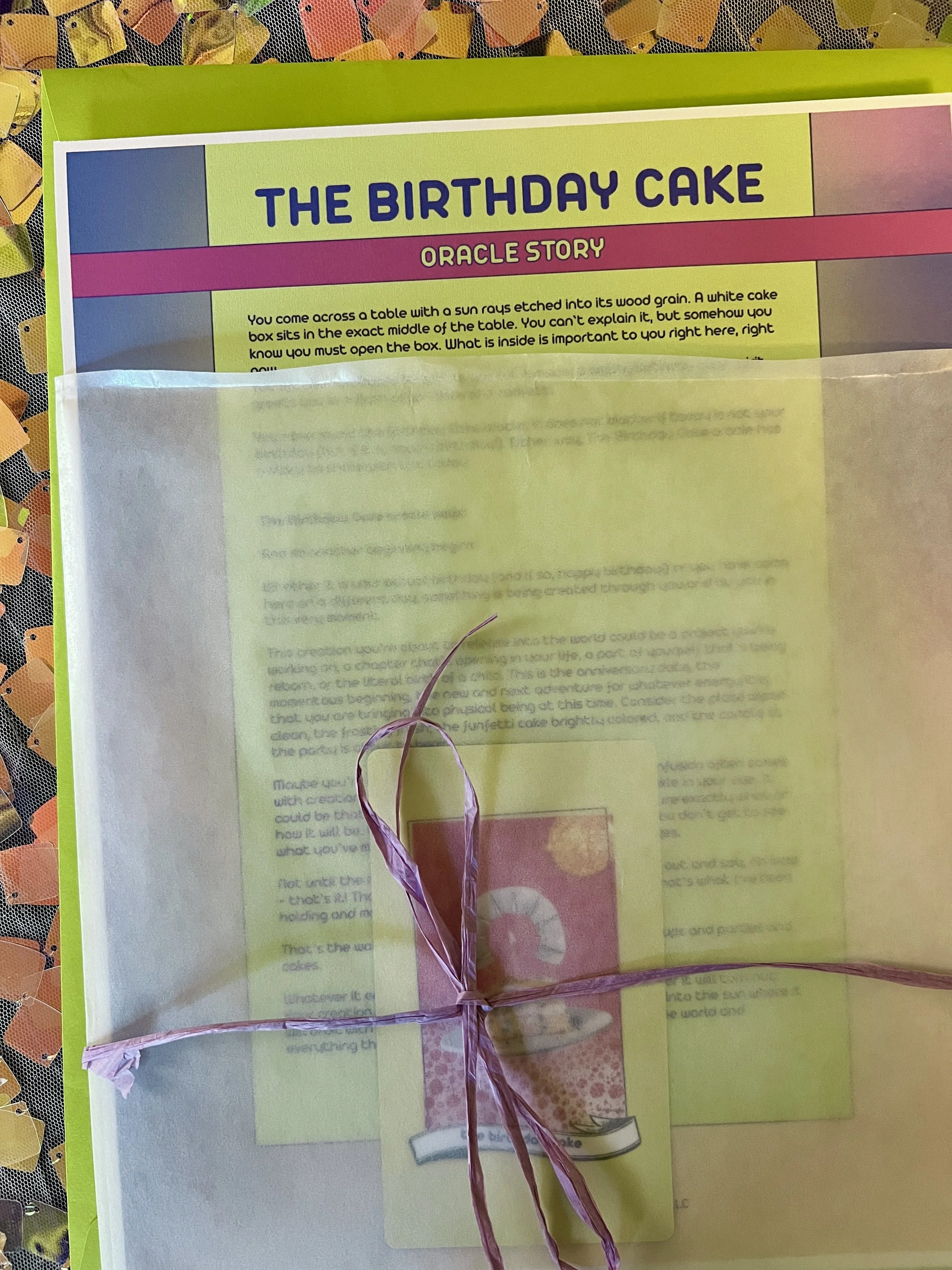 The Birthday Cake from Found Oracles printed story sheet peeking out of its glassine sleeve with story card visible inside.