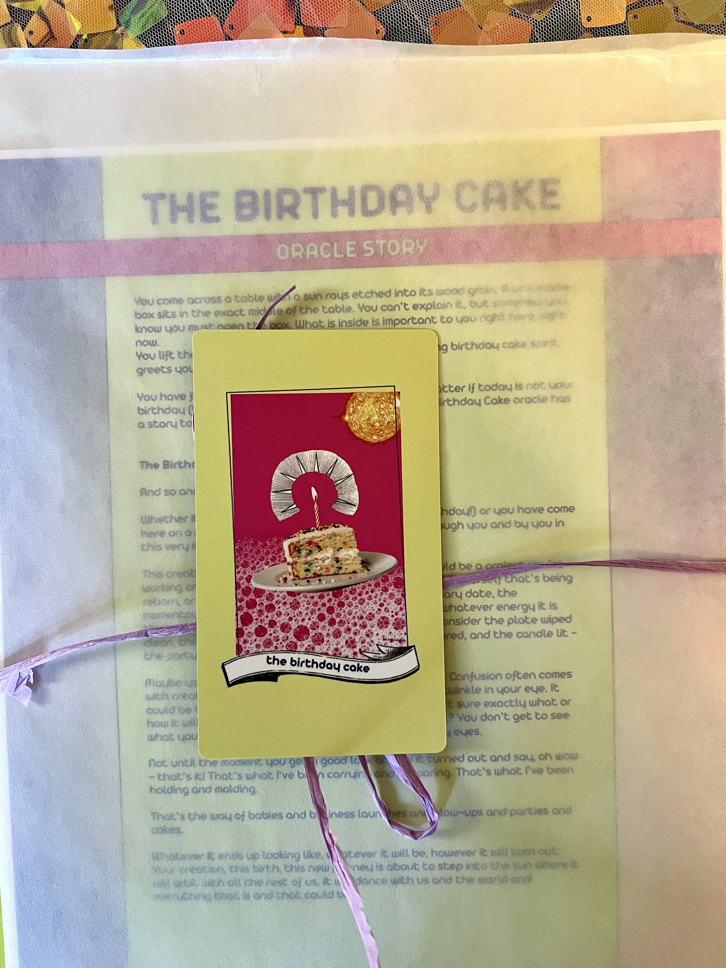 The Birthday Cake individual printed card and story sheet from Found Oracles shown bundled up with the card on top.