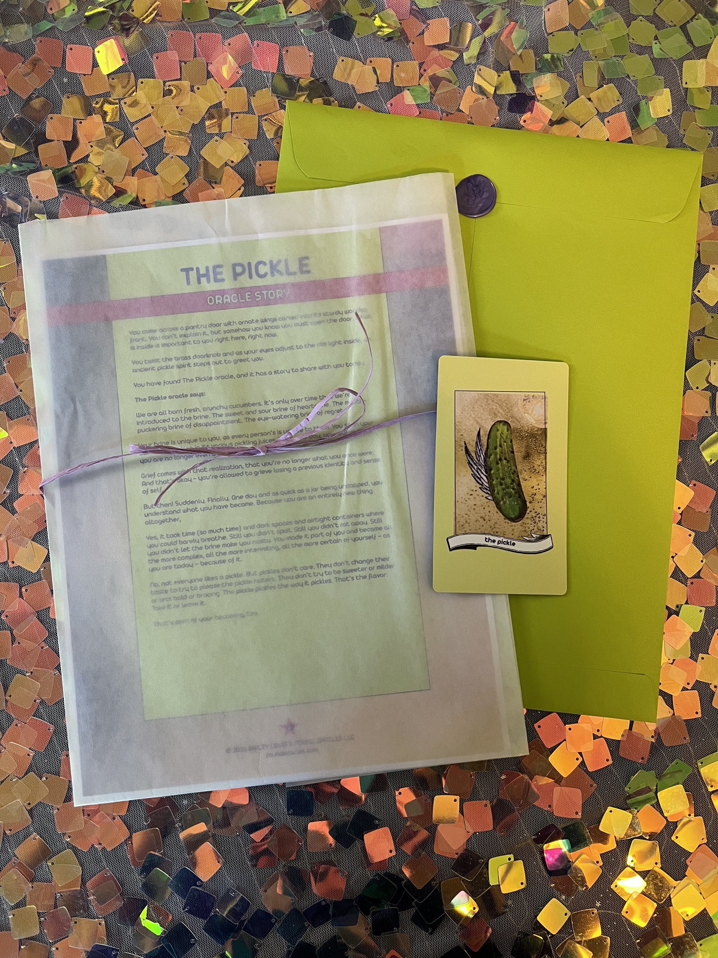 Flat lay shot of The Pickle printed story card and story sheet from Found Oracles with purple wax sealed green envelope behind.