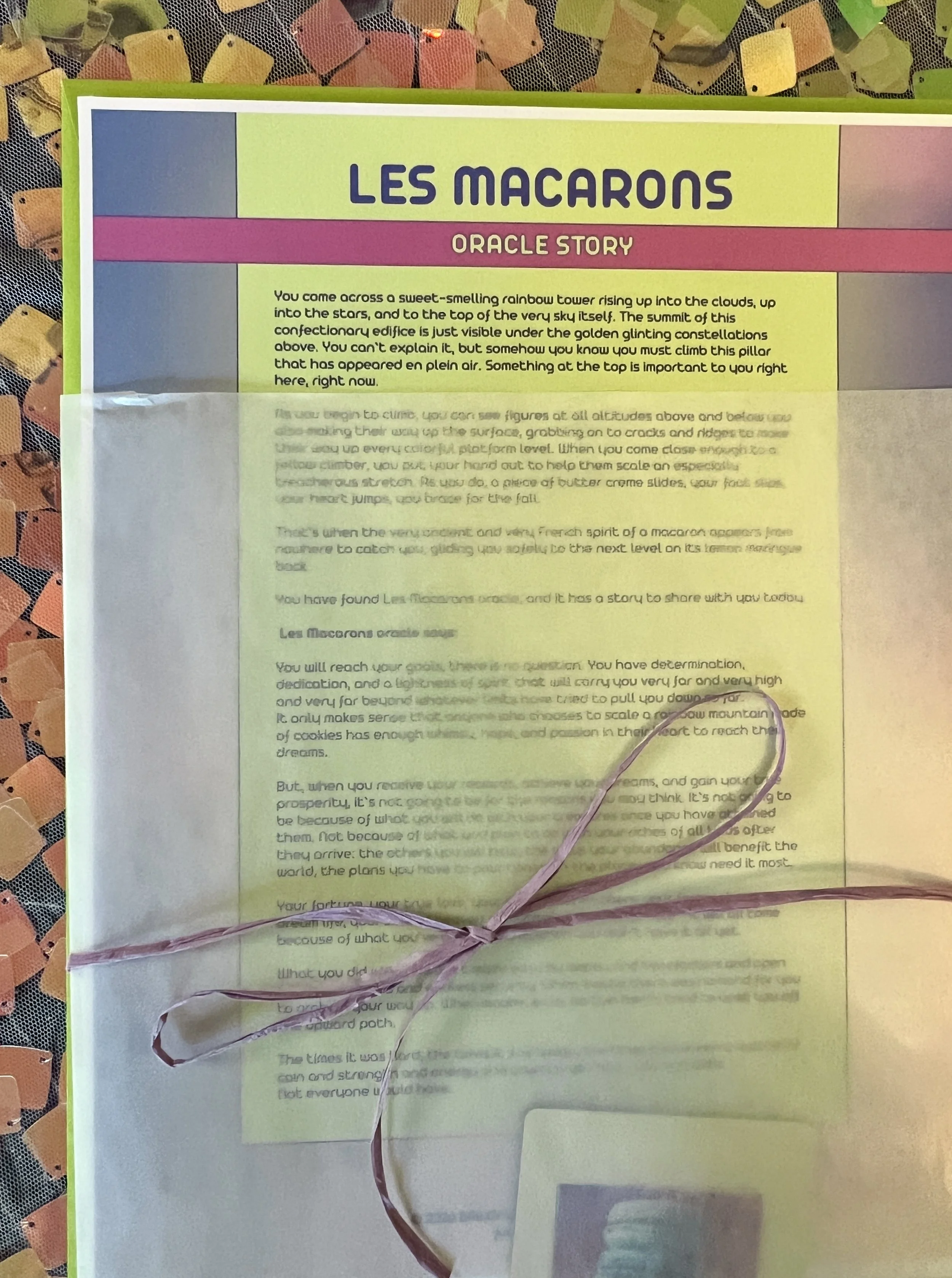 Les Macarons from Found Oracles printed story sheet peeking out of its glassine sleeve with story card visible inside.