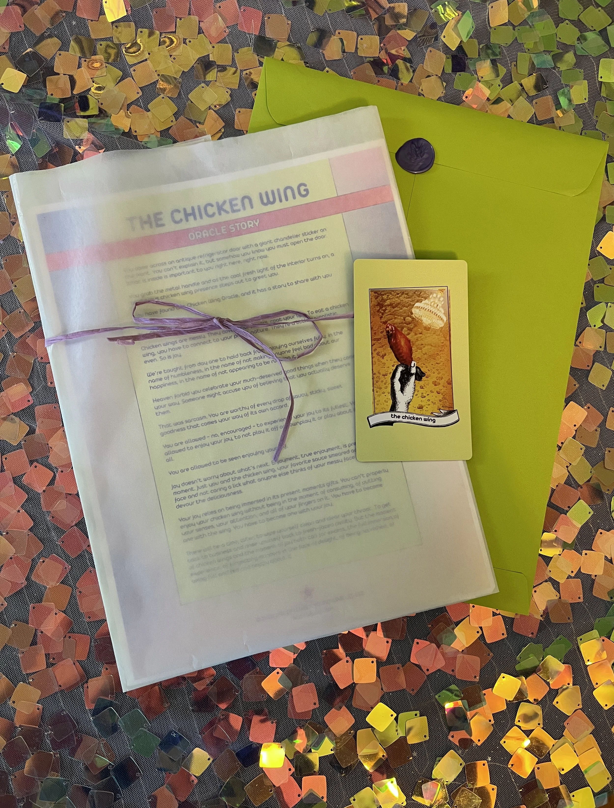 Flat lay shot of The Chicken Wing printed story card and story sheet from Found Oracles with purple wax sealed green envelope behind.