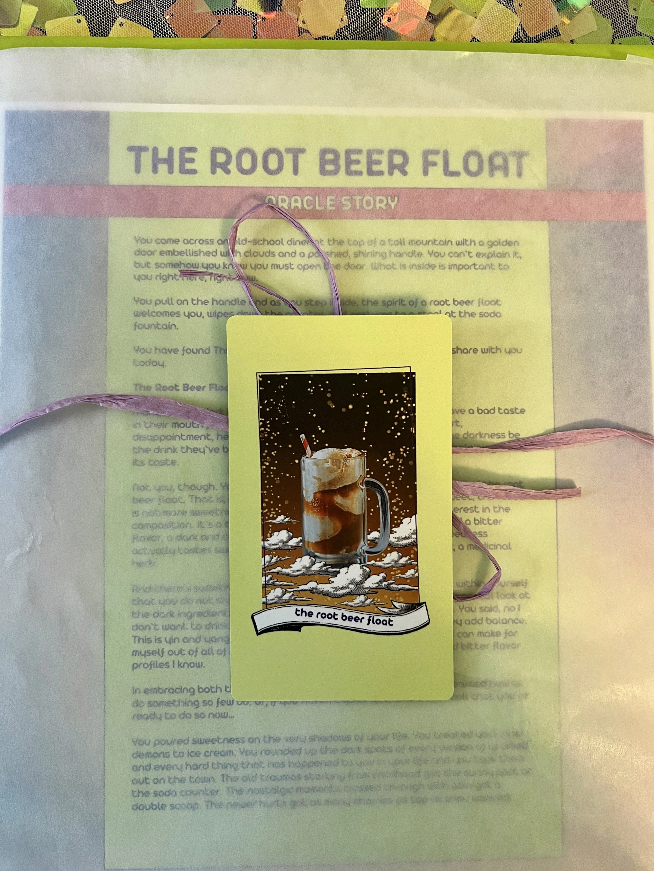The Root Beer Float individual printed card and story sheet from Found Oracles shown bundled up with the card on top.