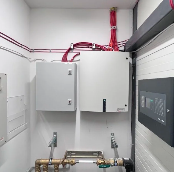 Electrical wiring and control panels in a utility room.