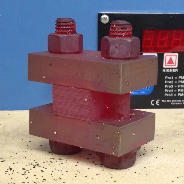 Red-hot billet in torque plates - fresh out of the kiln, ready to be hot-pressed.