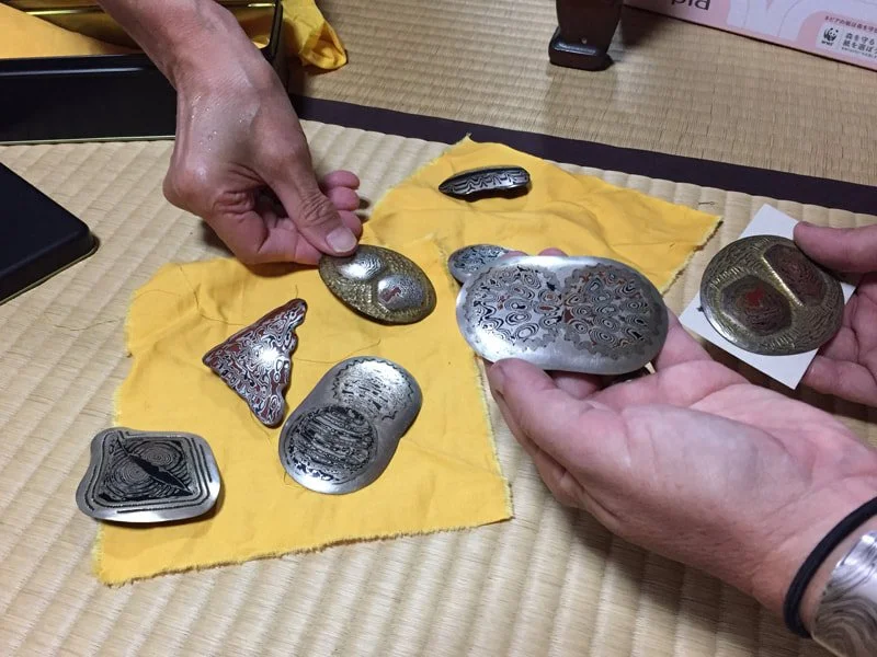  Couldn't choose, tried to refuse, so he chose for us. Ame got the triangle on the left, mine is not visible here, but it is a round piece of mokume on an oval of shakudo. 