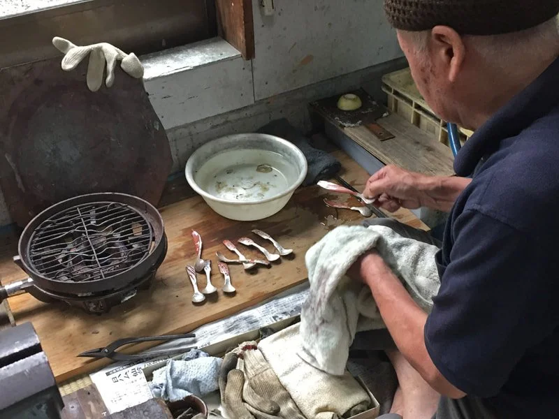  Here the patination with rokusho is done, and he's finishing up waxing the spoons with ibota wax. 