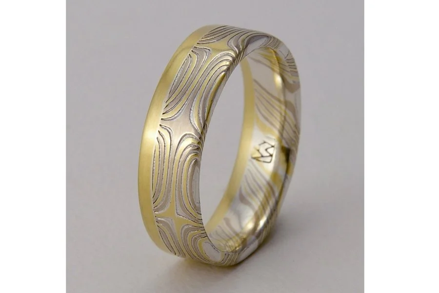 Kasai (Fire) ~ Star-patterned mokume gane makes this ring pop with energetic sparks of color. A thick solid edge of gold (rose, yellow or white) balances and unifies the highly-detailed star pattern. Available in 5 or 6mm width.