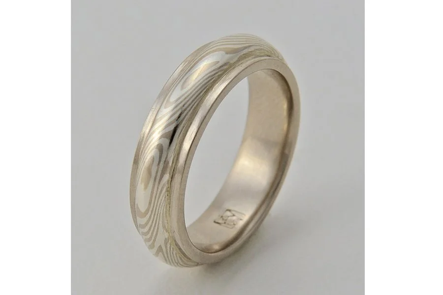 Sora (Sky) ~ A swirling dome of mokume flows around and above a solid band of gold (rose, yellow or white). The mokume pattern resembles cloud formations flowing and changing in the sky. Looks best from 5 up to 9mm wide.