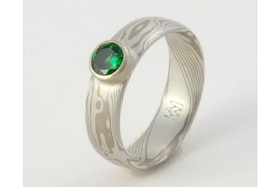 Woodgrain pattern mokume gane with a luscious green tsavorite garnet. Mokume is (WS) 14k palladium white gold and sterling silver, with a smooth finish.