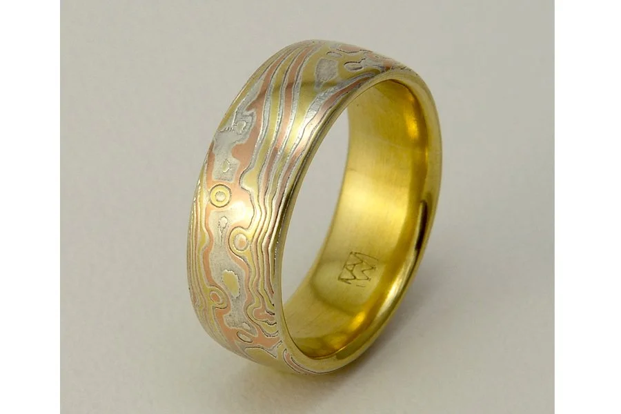 Mizu (Water) ~ Flowing, organic lines and swirls represent the changing flow of water in river, lake, surf and sea. This style is always lined with solid rose, yellow or white gold. Looks great from 4mm up to 9mm wide.