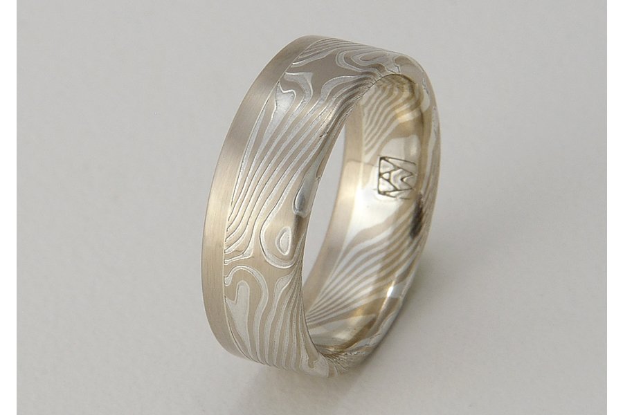 Kaze (Wind) ~ Swirling lines of mokume resemble the path of a breeze moving through trees. One solid edge of gold (rose, yellow or white) calms and anchors the design. Available from 5 to 8mm wide. This selection is sterling silver and 14k palladium 