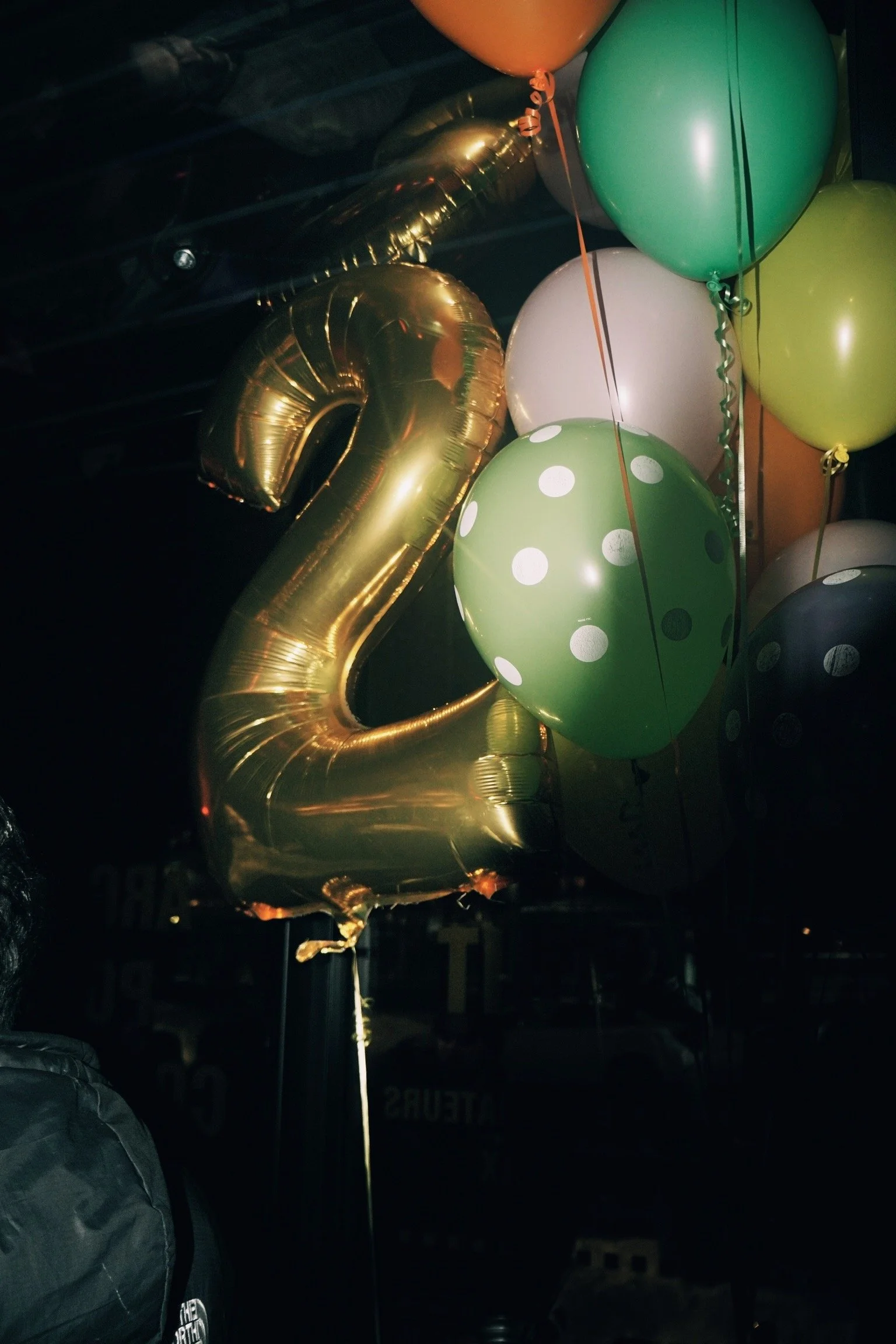 Un verre de cocktail avec de la glace, une tranche de citron vert, des feuilles de basilic, une paille en plastique, sur un fond blanc.