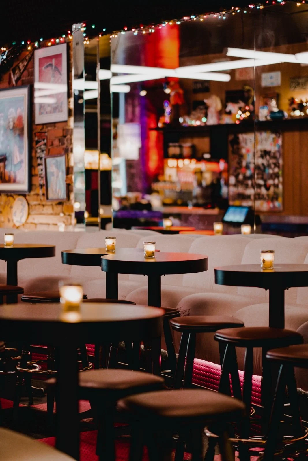 Cocktail tropical avec garnitures de fruit, parasol en papier bleu, paille en plastique, et fruits en décoration, présenté dans un verre tulipe.