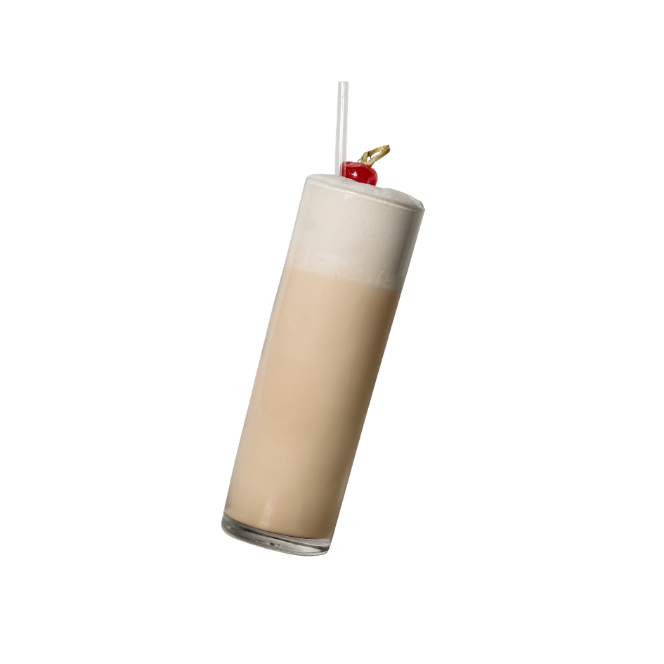 Un cocktail dans un verre haut avec une crème blanche en haut, garnie d'une cerise rouge et d'une petite broche, avec une paille
