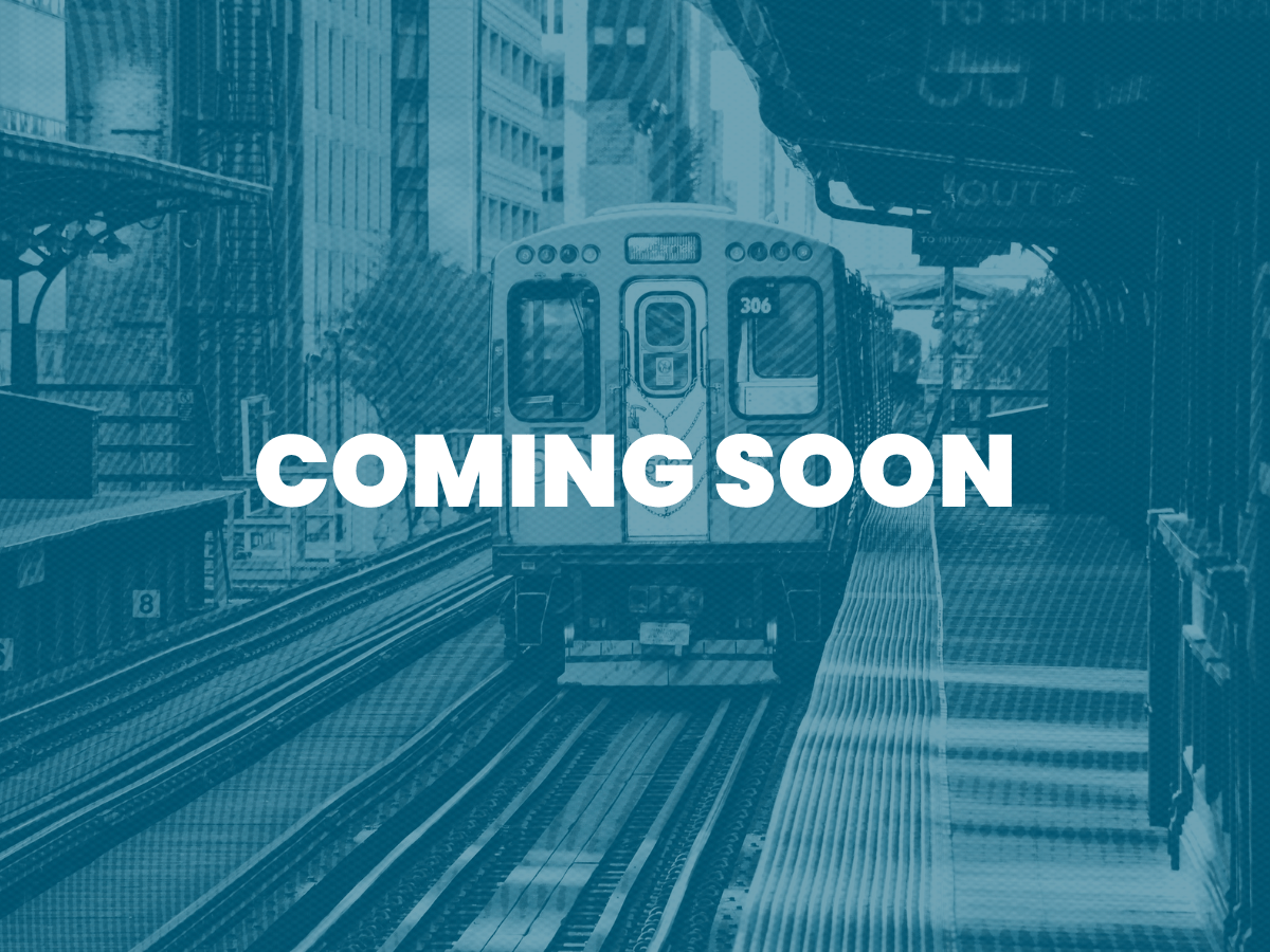 An elevated train arriving at a city station with buildings in the background, overlaid with the words "COMING SOON".