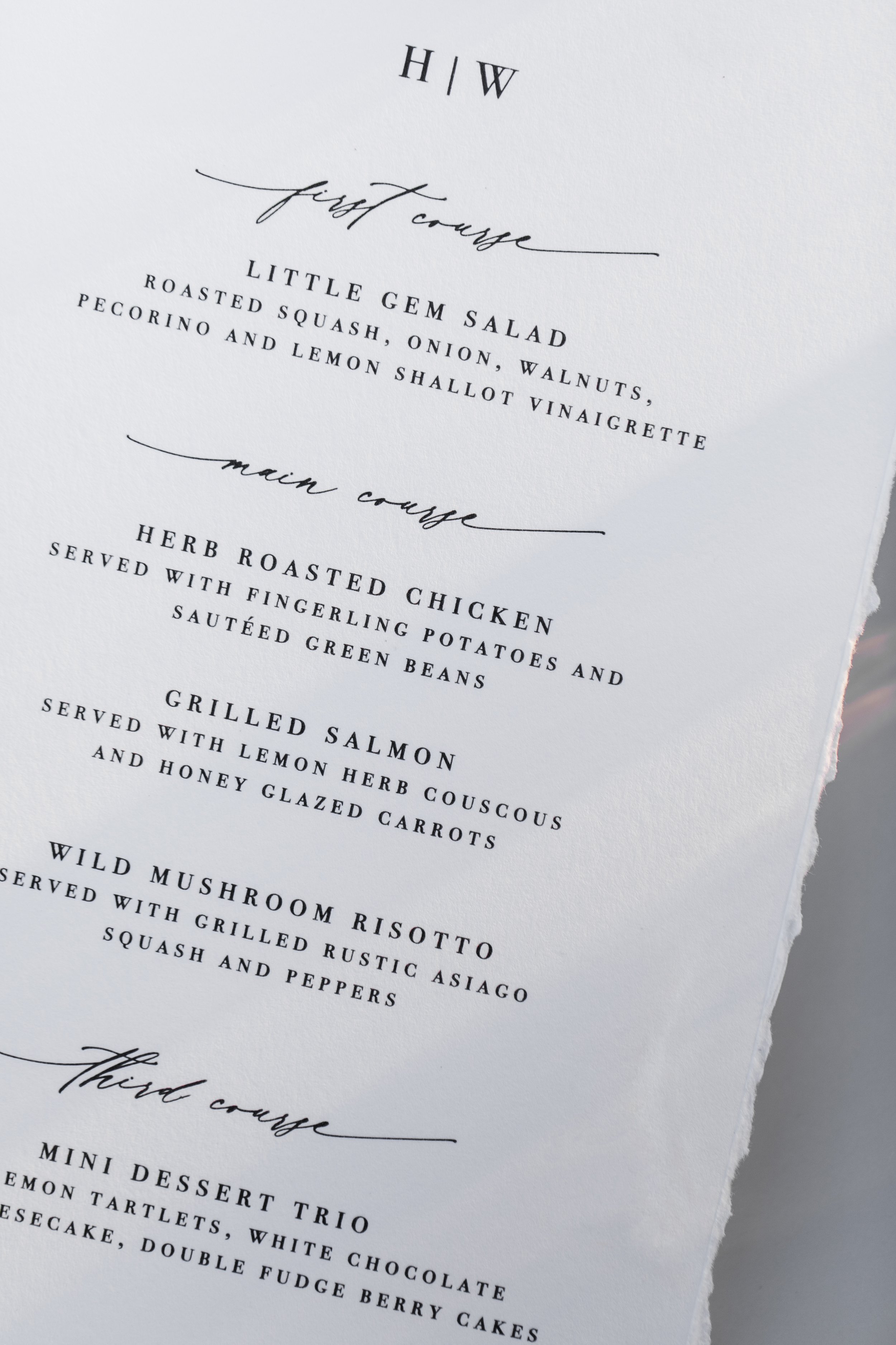 A printed menu with courses including Little Gem Salad, Herb Roasted Chicken, Grilled Salmon, Wild Mushroom Risotto, and a Mini Dessert Trio.