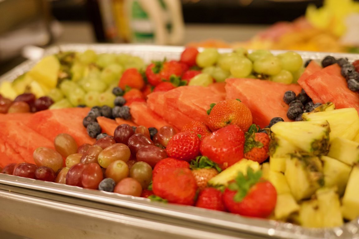 Tray of assorted fresh fruits including strawberries, watermelon, grapes, blueberries, and pineapple.