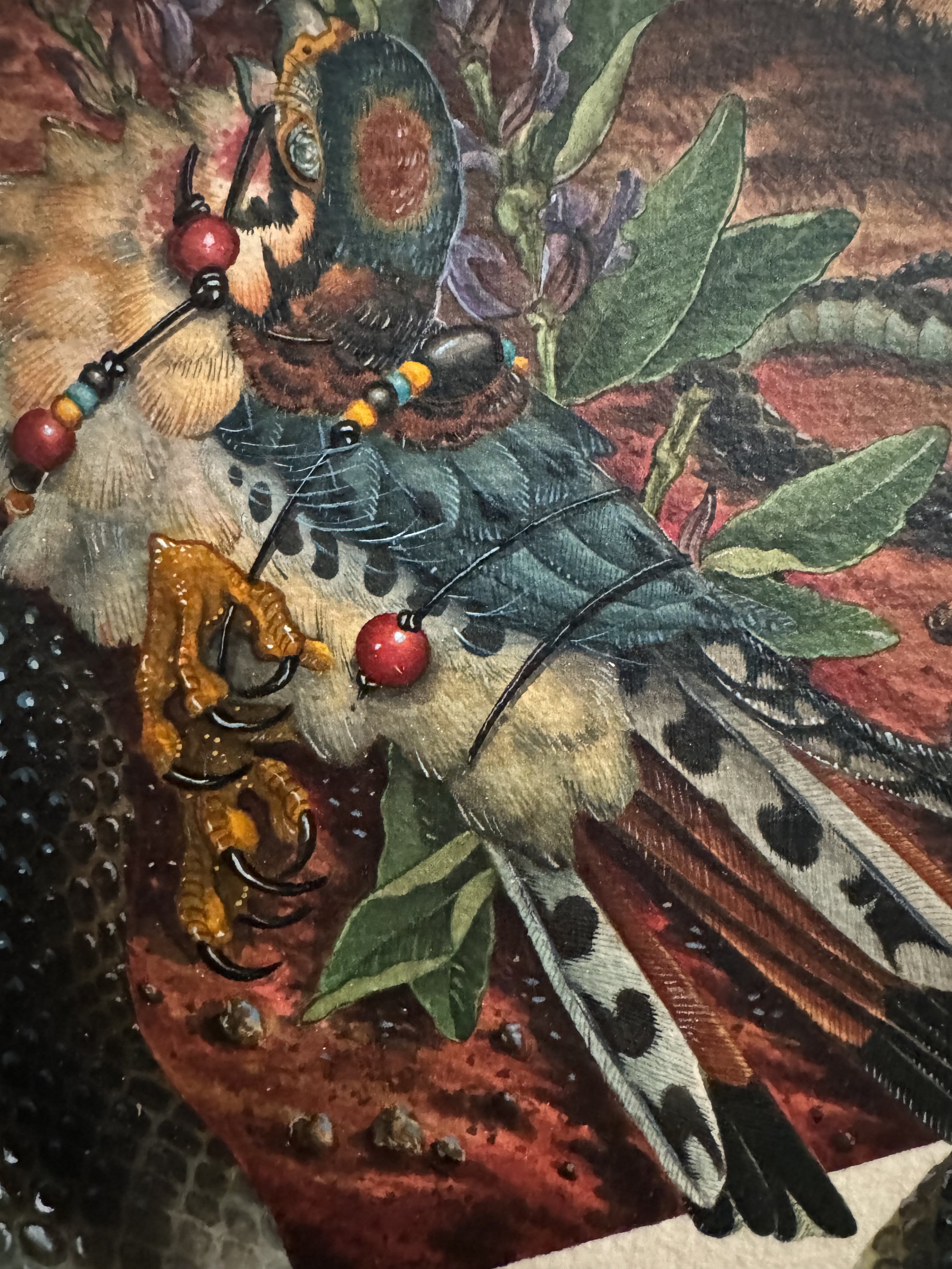 Close-up of a vintage-style illustration of a butterfly, bee, caterpillars, and foliage, with a beaded necklace draped over the butterfly.
