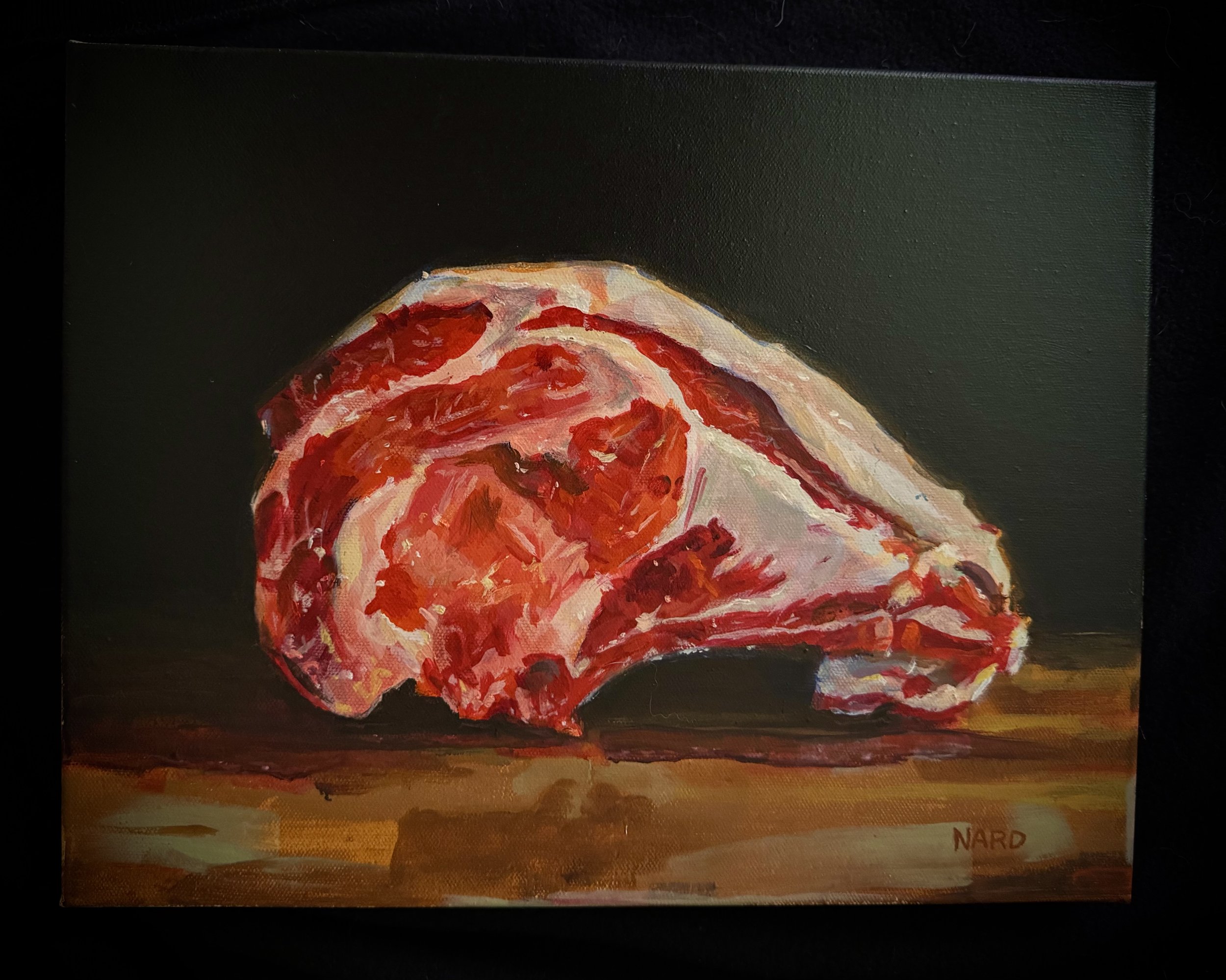 Painting of a raw piece of meat, possibly steak, on a wooden surface, signed 'NARD' at the bottom right.