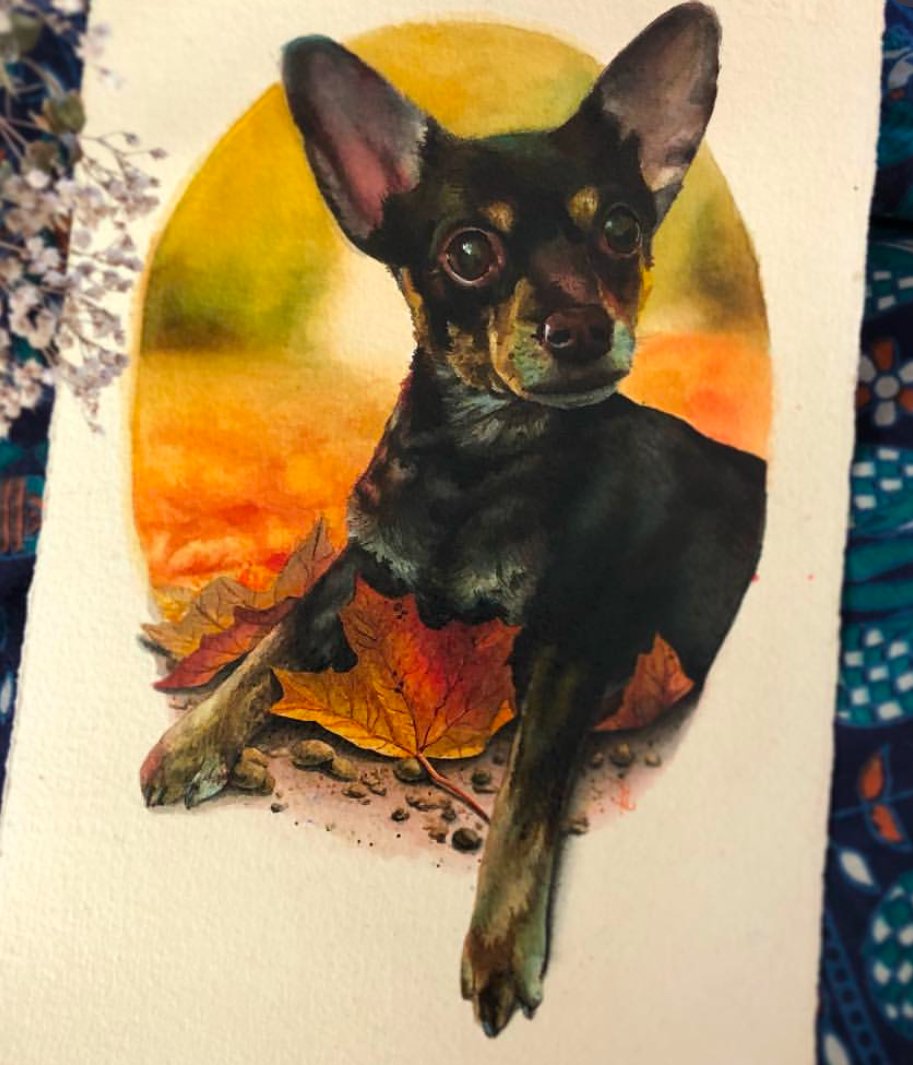 Another commissioned pet portrait painting of a small black and brown dog with large ears, sitting on the ground surrounded by fallen autumn leaves. The background features a circular gradient of warm colors, resembling a sunset.