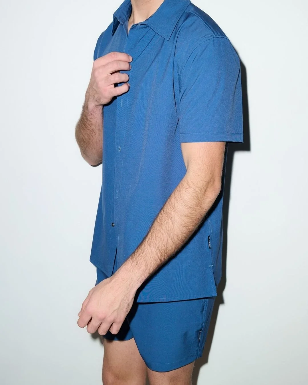 Man in blue cabana set standing against a white background.