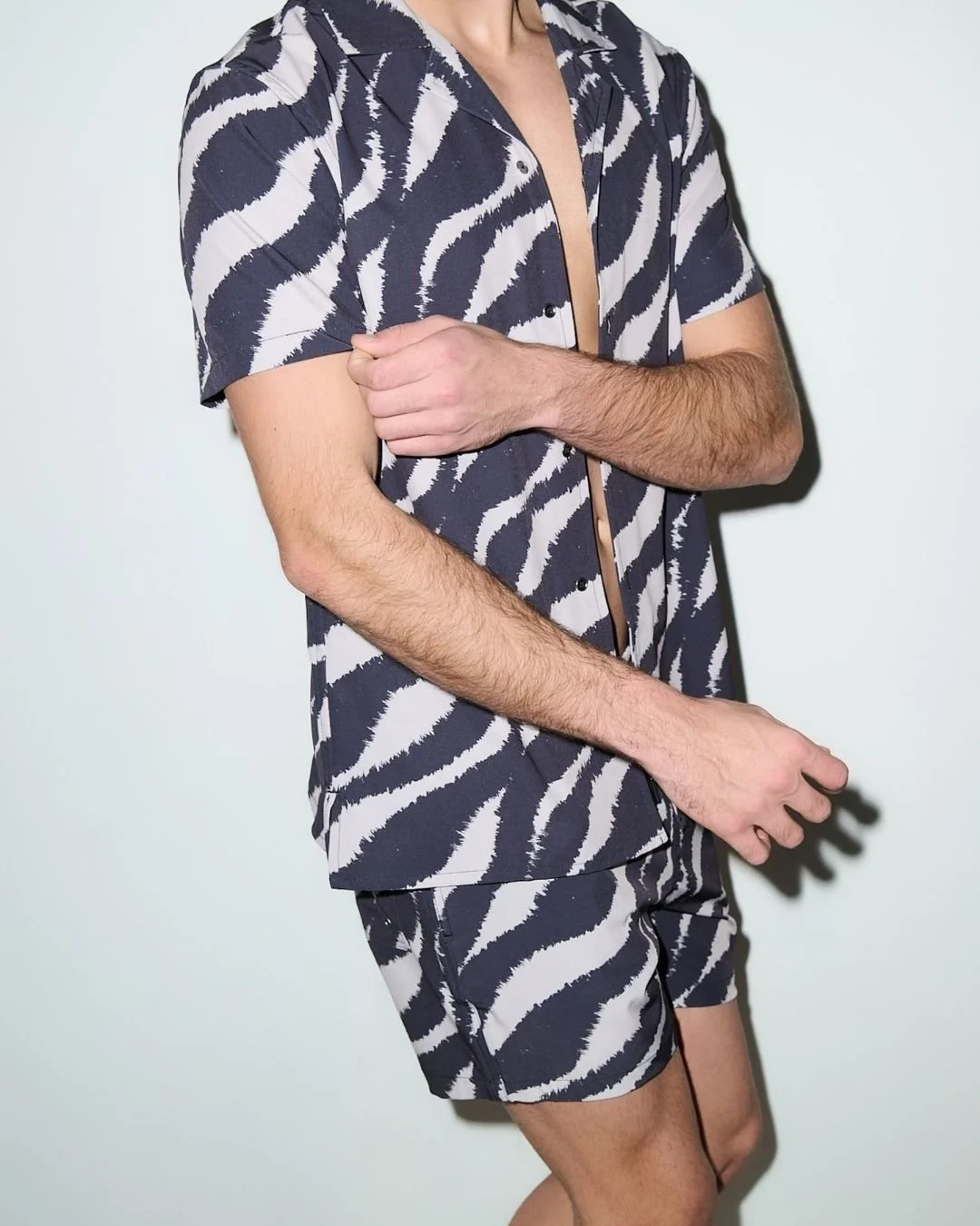 Close-up of a man wearing a zebra-print matching short-sleeve shirt and swim shorts.