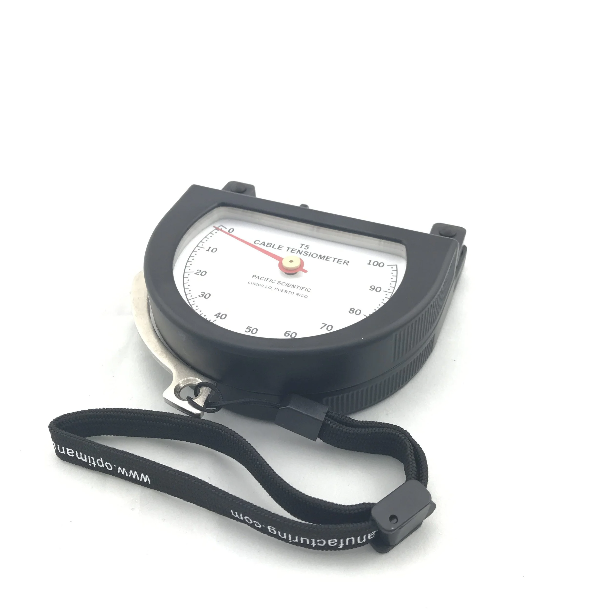 Cable tension meter with a black casing and a white face, marked with a red needle pointing to zero, and a black lanyard attached.