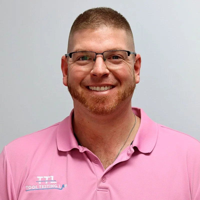 A young woman with dark hair styled in a messy top bun, smiling and wearing a white shirt.