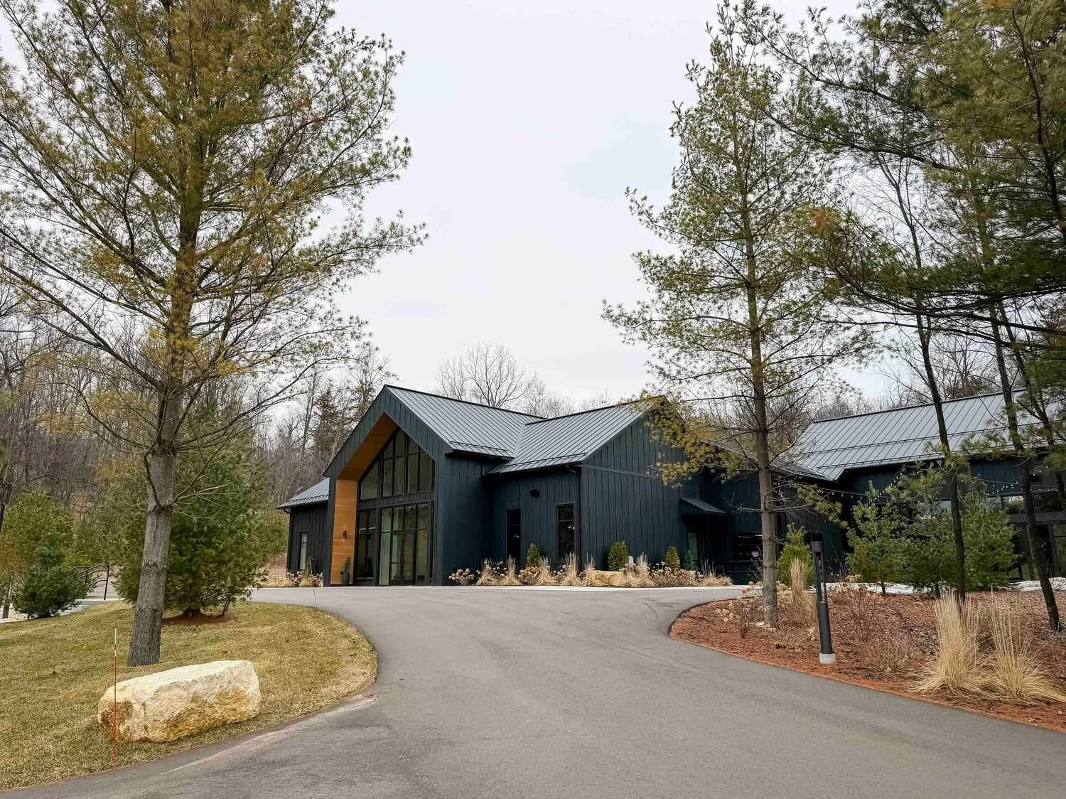 Front of the Woods & Co wedding venue that's all black with a very large glass entrance with a horseshoe driveway