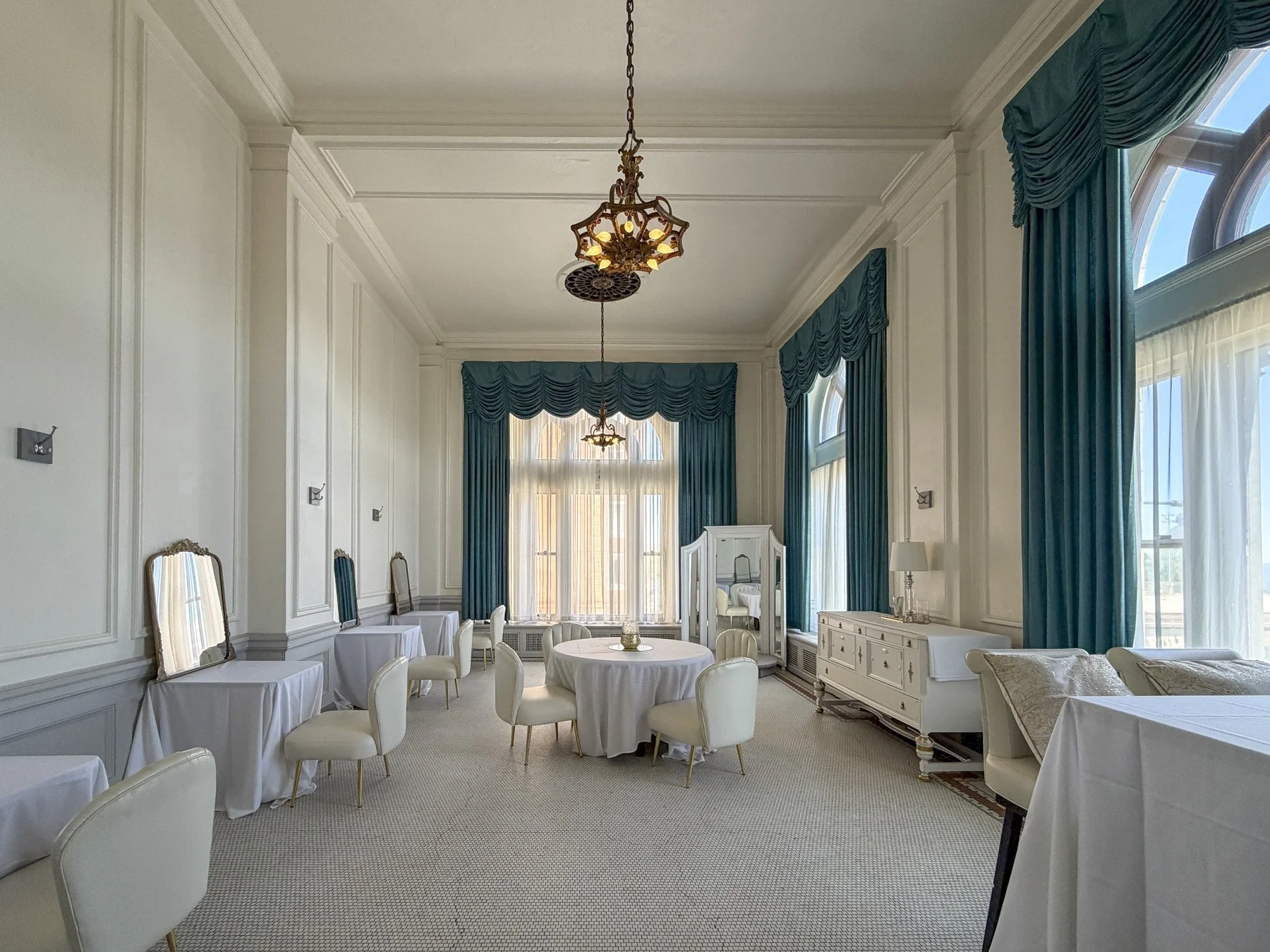 Stunning bridal suite in duluth with beautiful white walls, mirrors, and vintage teal curtains that vibrant and pull the room together