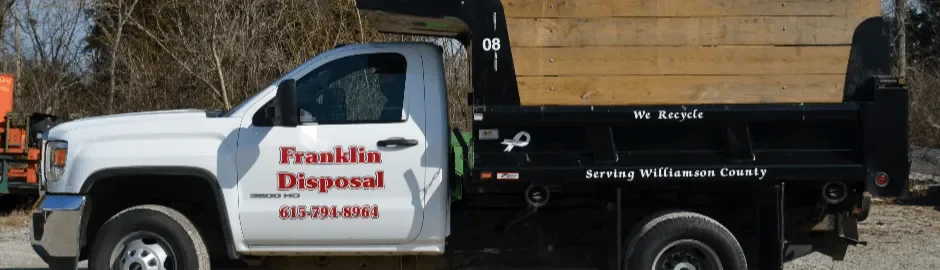 White and black Franklin Disposal pickup truck with wood bed and recycling message