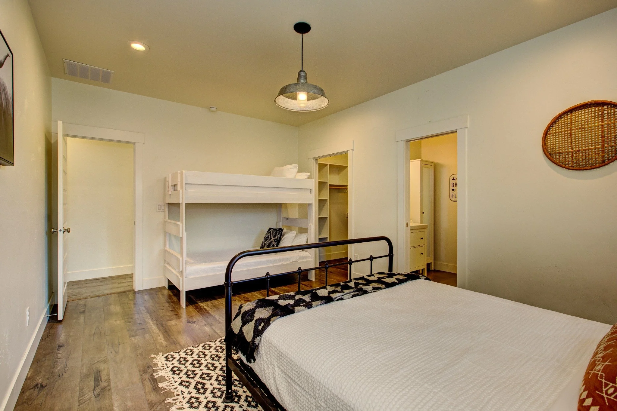 Farmhouse guest room with a bed and bunk beds.