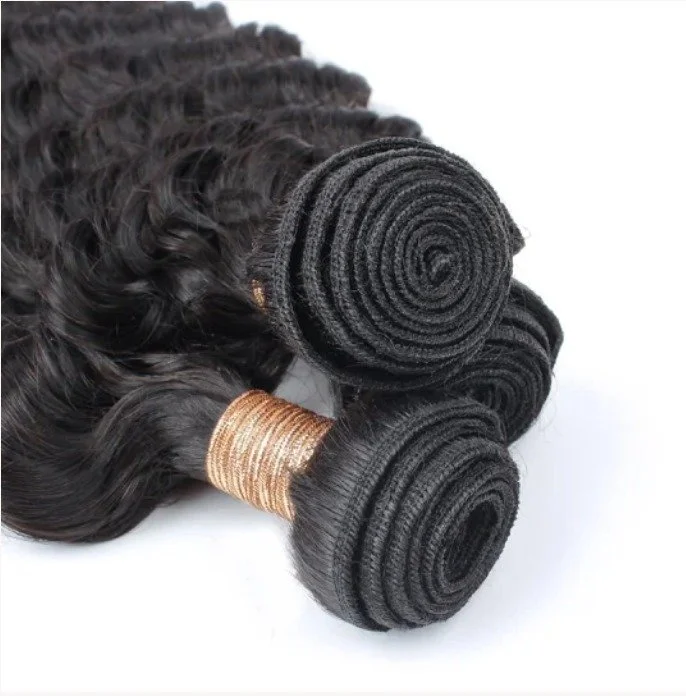 Bundles of black curly hair extensions and weave closures.