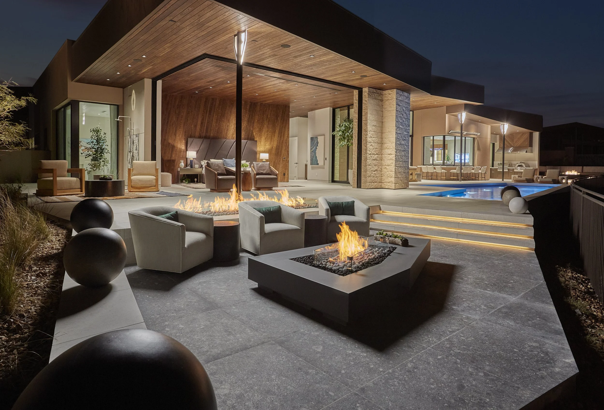 outdoor firepit with pool and house in the background