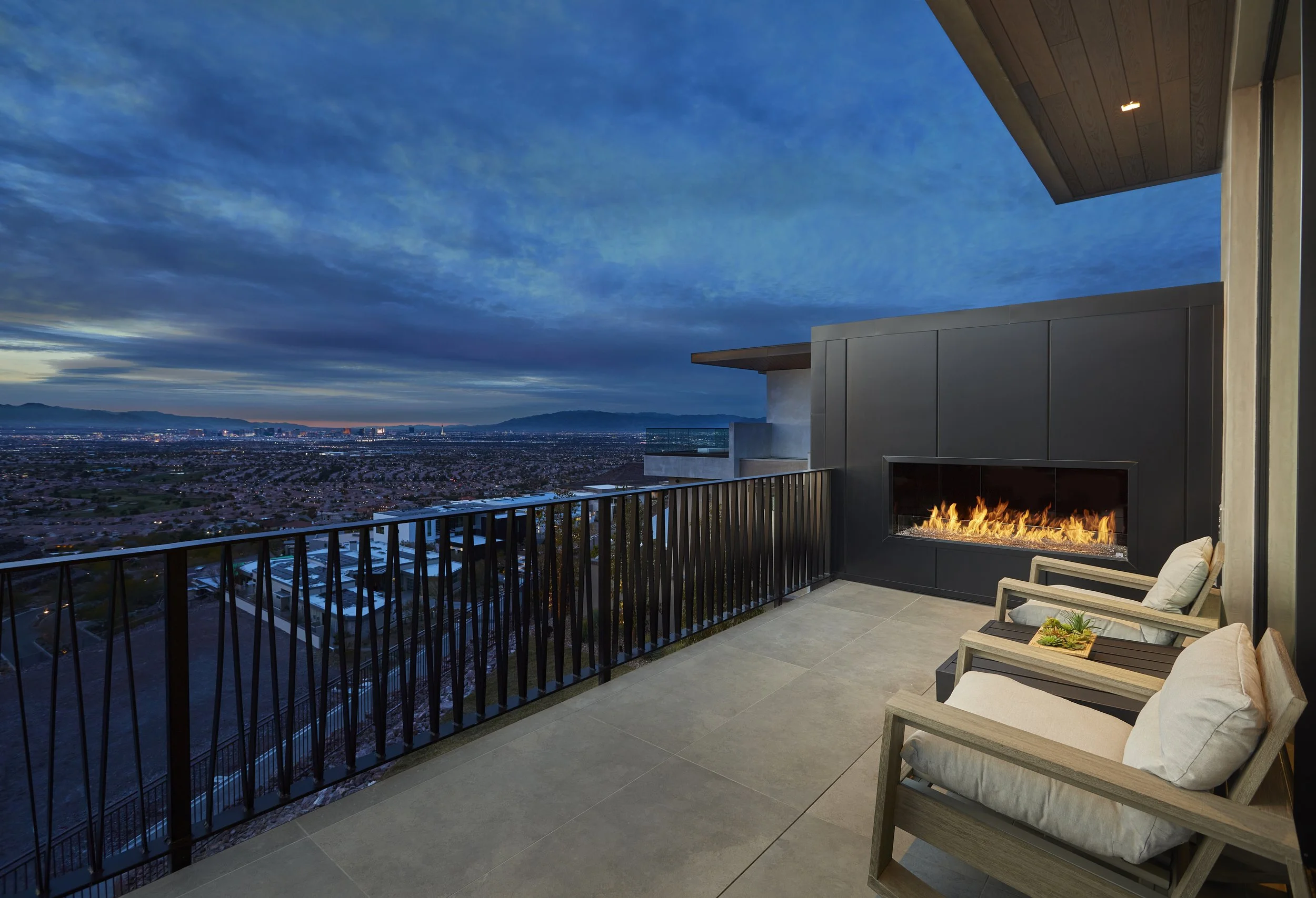an outdoor gas fireplace with a view of the city and moutains