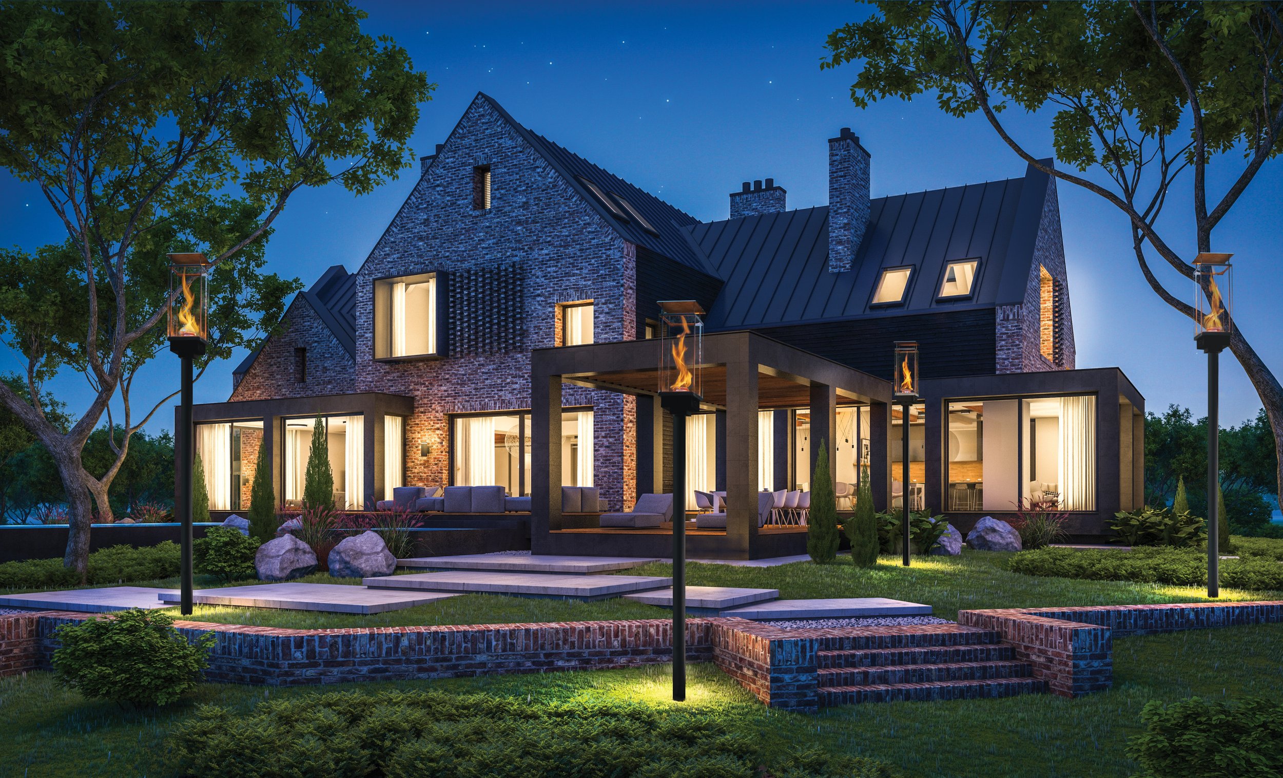 brick home with lots of windows at dusk with torches and landscape