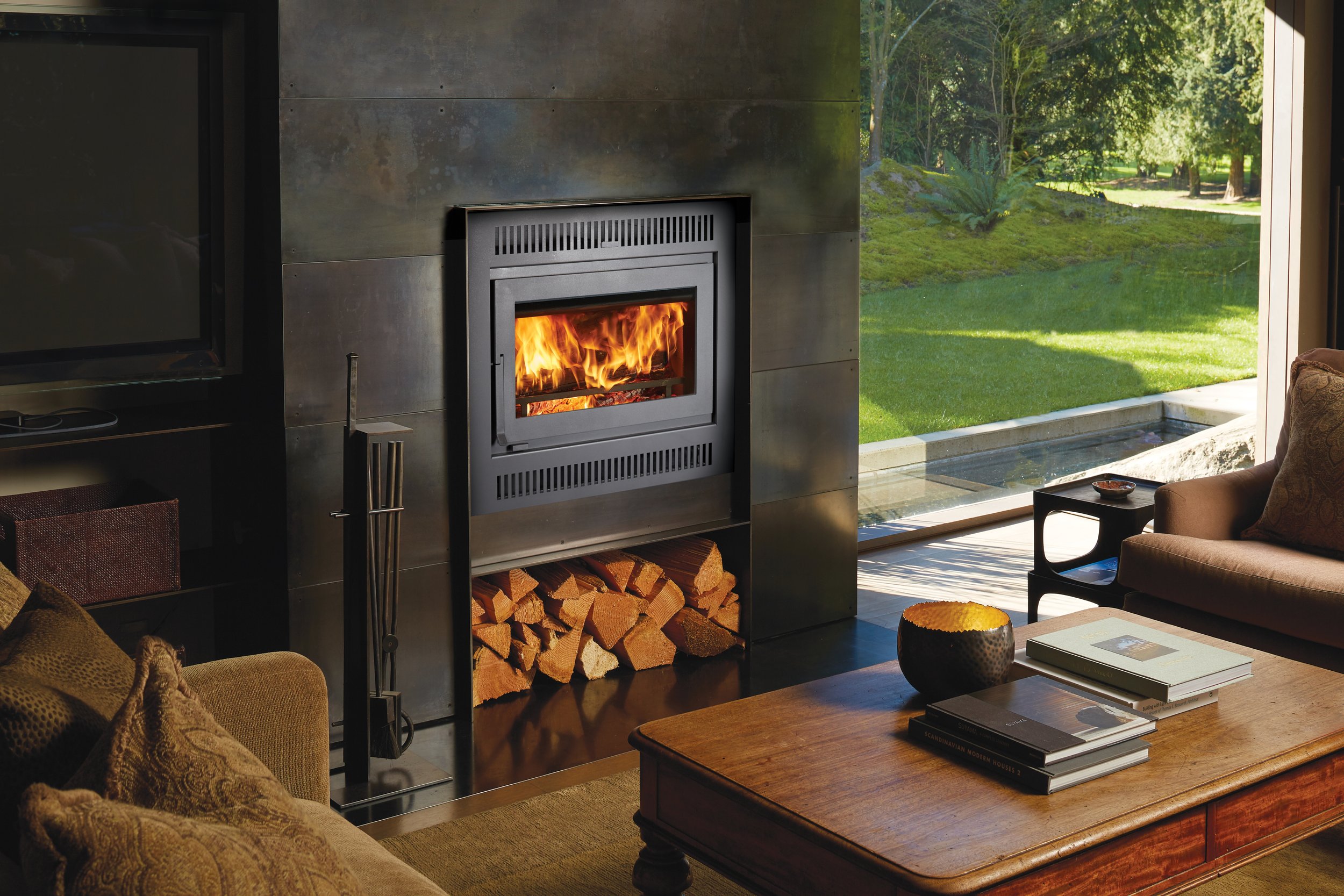 wood fireplace in a living space with green grass in the background