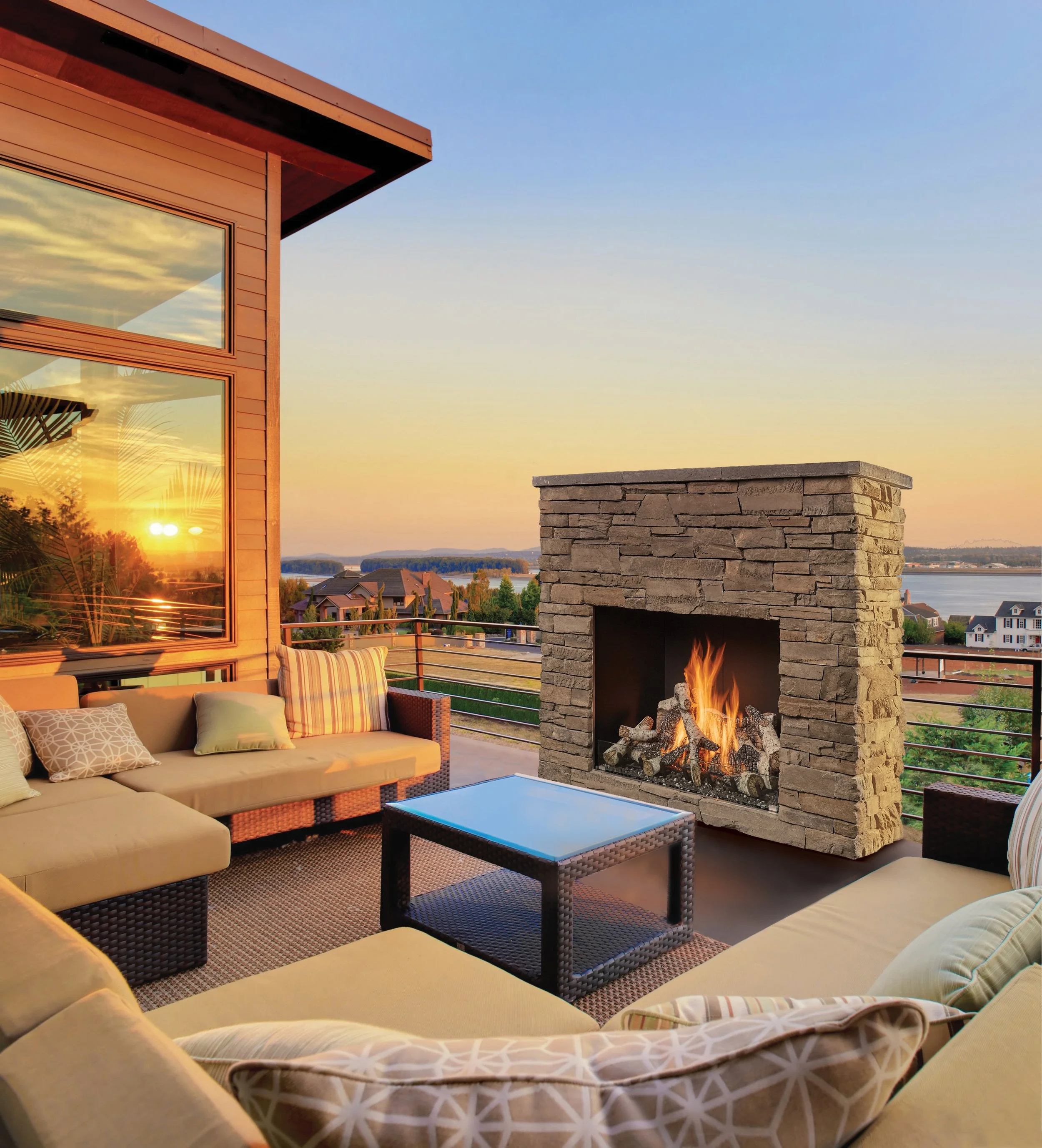 a traditional outdoor gas fireplace on a back patio at sunset