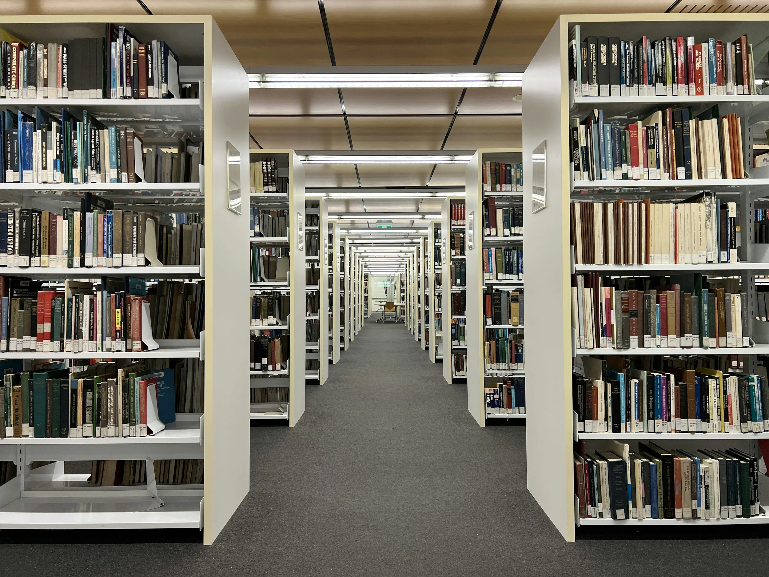 library shelves going off into the distance are filled with books