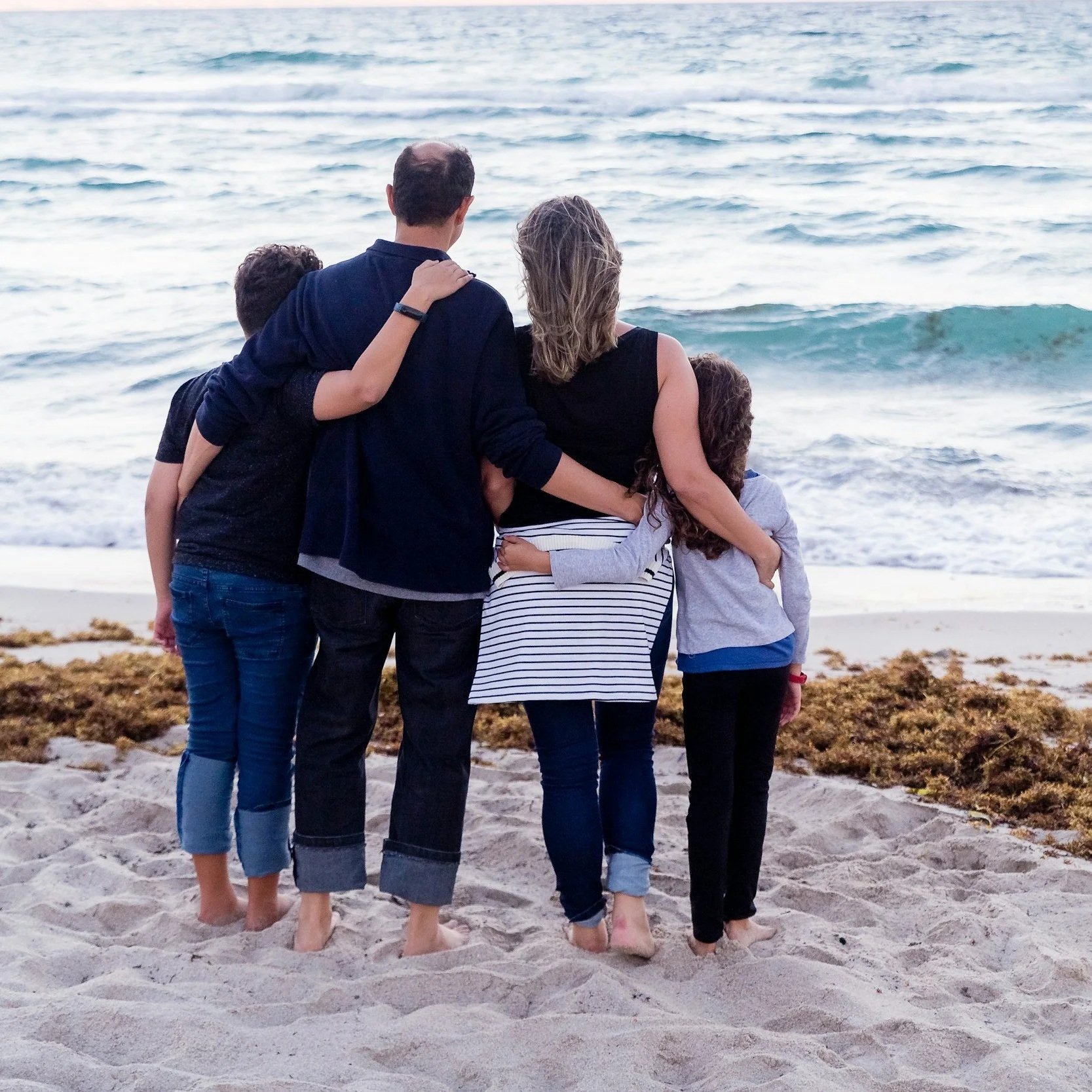 image behind a button showing a family looking out at the ocean