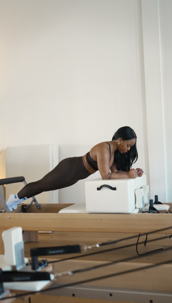 Close-up of a woman in a sports bra, capturing her shoulder and neck, with her hair tied up in a bun.